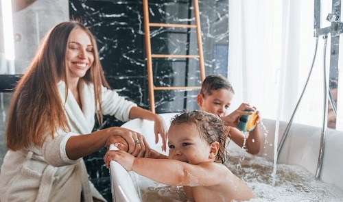 vrouw wast kinderen in bad